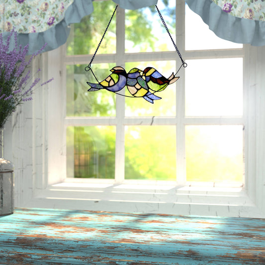 Three Birds Perched on a Branch stained glass piece.  Shades of blue, green, yellow, orange  will light up your room with charm and color!  The piece  is  11.5"L x 0.25"W x 4.5"H and comes with a 31.75" metal chain for hanging.