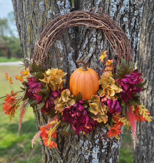 This 14 inch Fall Grapevine Wreath is filled with vibrant fall colored florals and an artificial pumpkin. Perfect for the fall, Thanksgiving season on your front door or inside above the mantel! It measures 21 x 21 x 4 inches from tip to tip and is uniquely handmade.